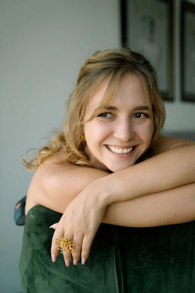 Woman with a gold ring smiling indoors