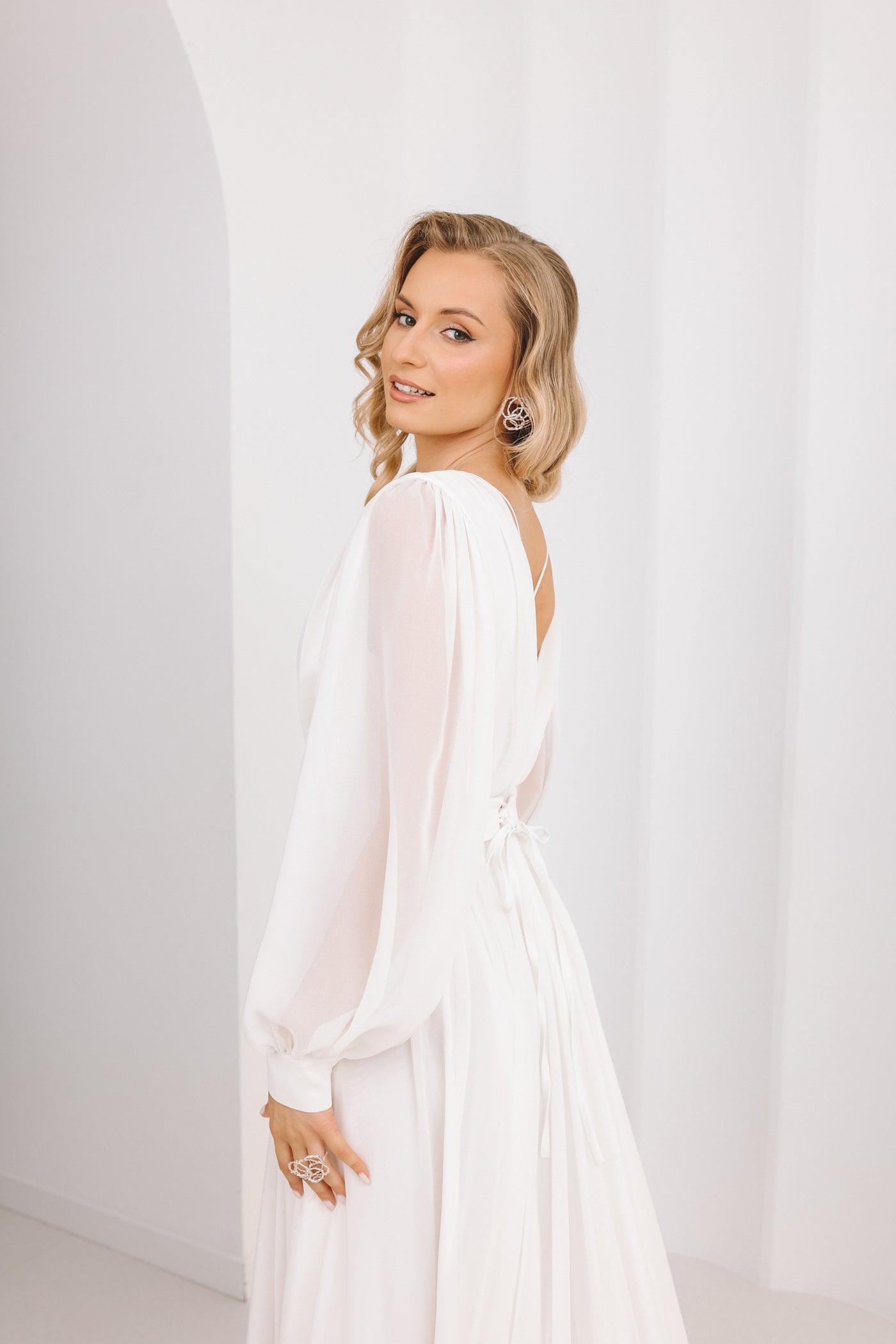 Woman wearing a white dress against a plain background